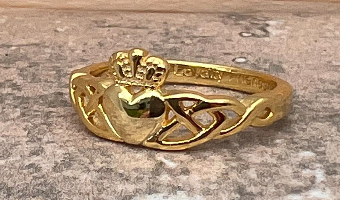 14 CT, Gold Coated Sterling Silver  Claddagh ring with two trinity’s on either side of the heart .