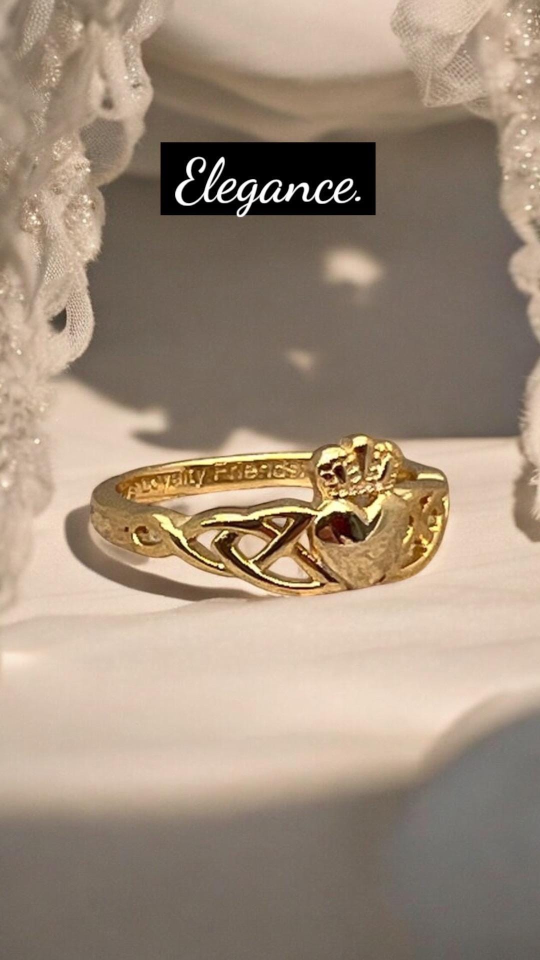 14 CT, Gold Coated Sterling Silver  Claddagh ring with two trinity’s on either side of the heart .