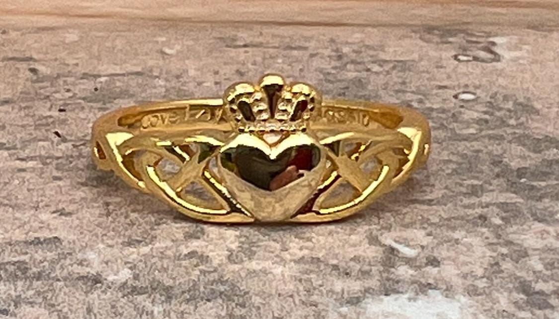 14 CT, Gold Coated Sterling Silver  Claddagh ring with two trinity’s on either side of the heart .